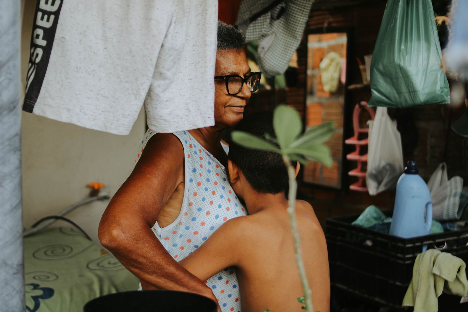 A grandmother and her grandchild share a warm hug at home.