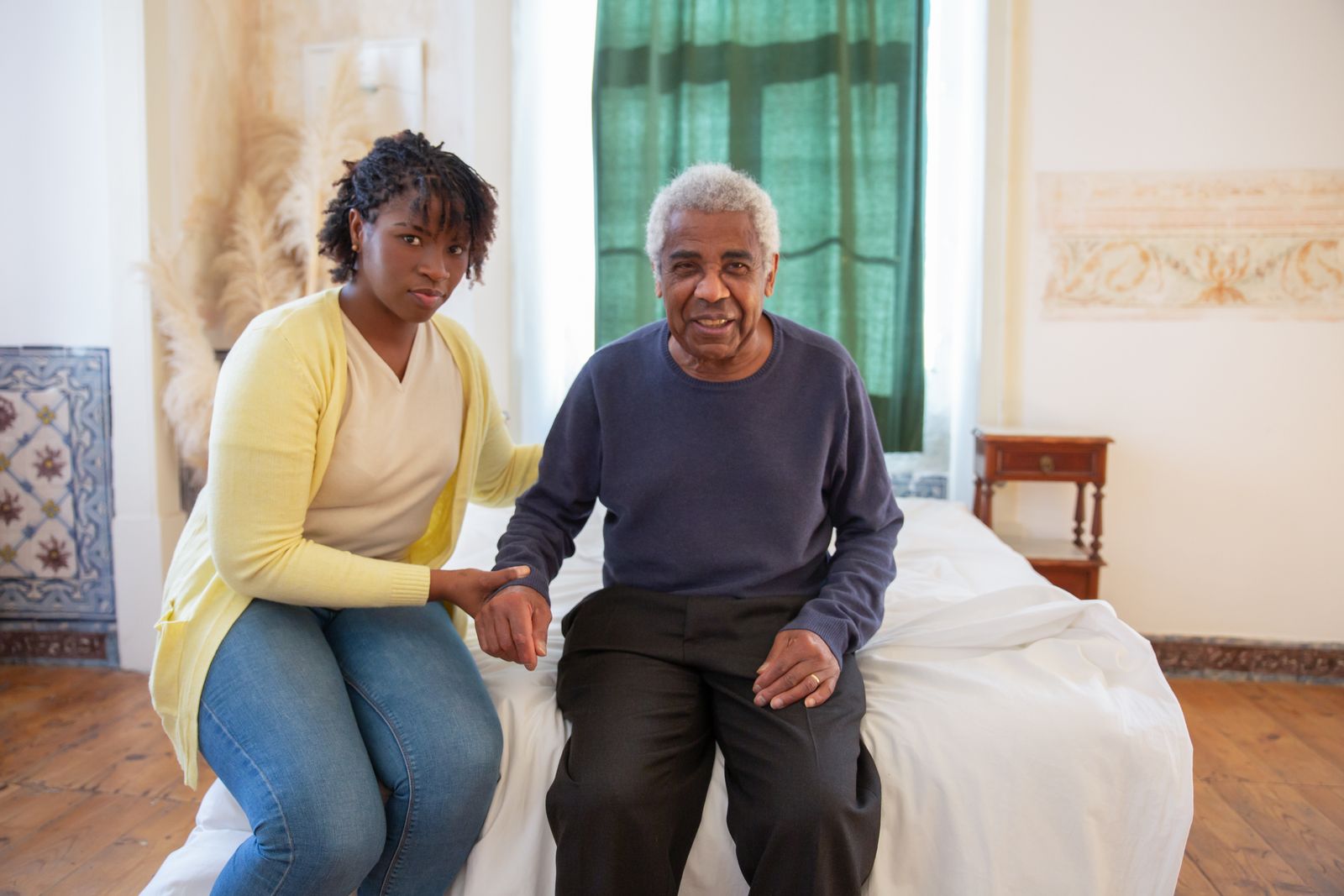 A carer sitting with an older man at home.